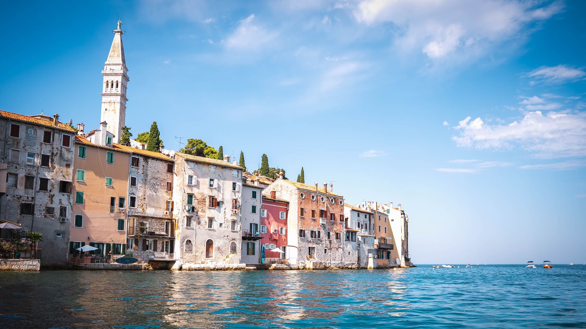 Rovinj nad morzem z kolorowymi kamienicami i wieżą kościoła w słońcu