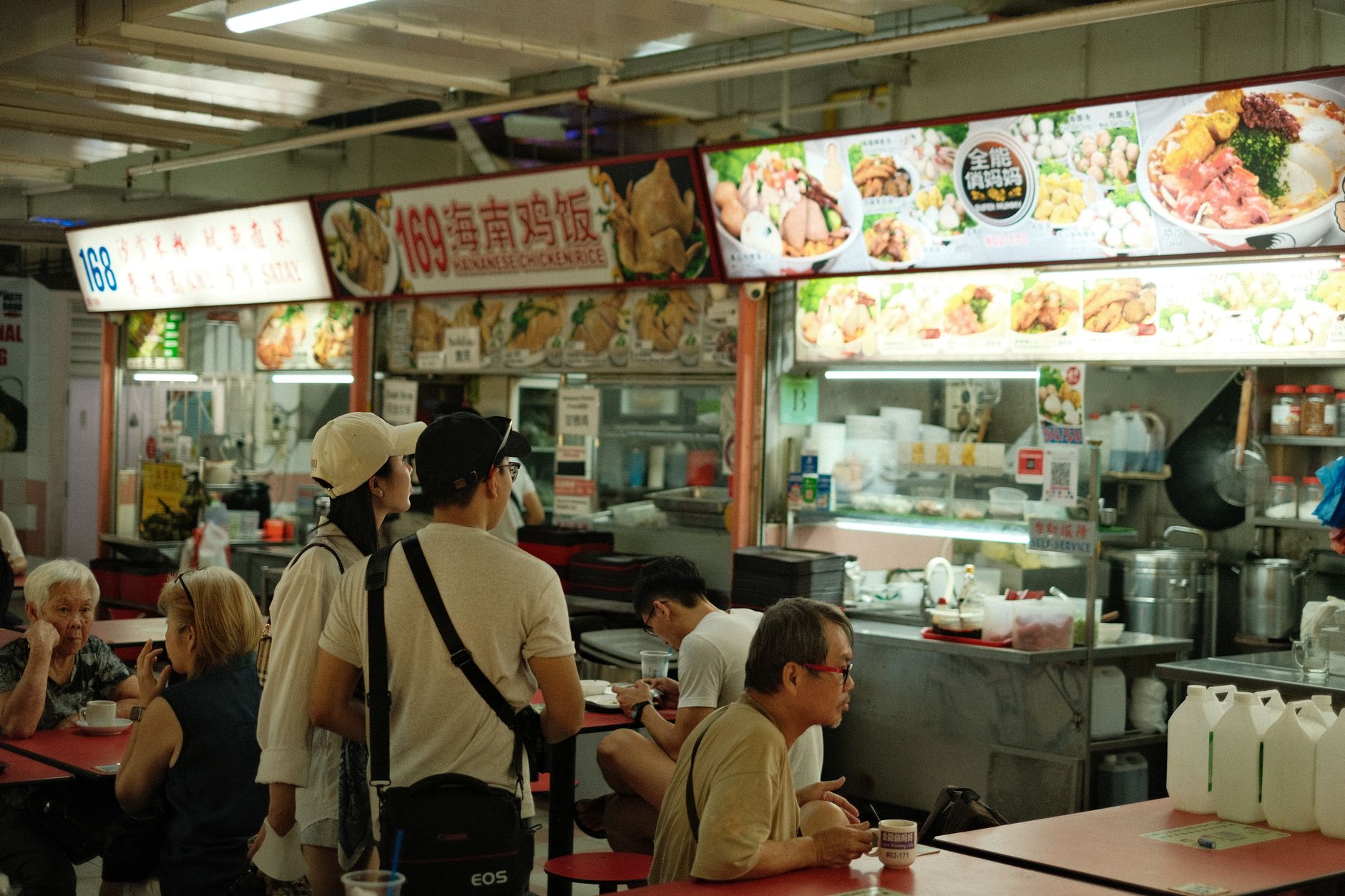 Goście jedzą lokalne potrawy w singapurskim hawker centre