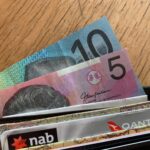 Australijskie dolary i karty płatnicze w portfelu na drewnianym blacie